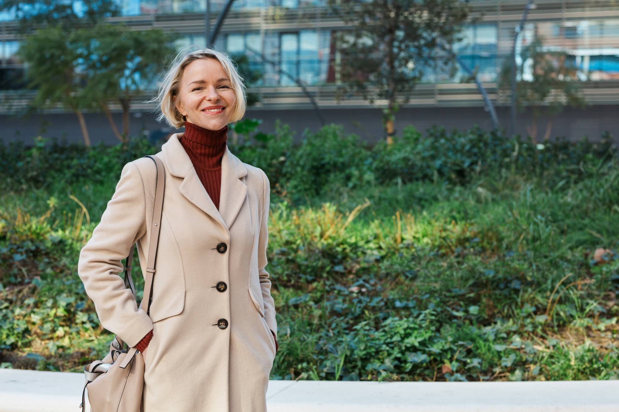 Stylish business woman smiling while standing outdoors in the financial district